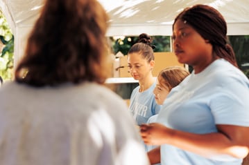 image-showing-female-volunteer-crew-charitable-center-distributing-free-food-less-privileged-vicinity-seen-are-voluntary-individuals-helping-poor-homeless-people